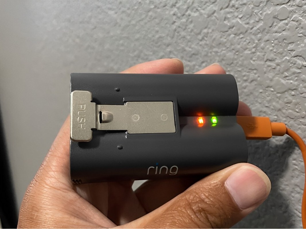 Ring Battery Doorbell connected to a charger, showing the charging process for the battery