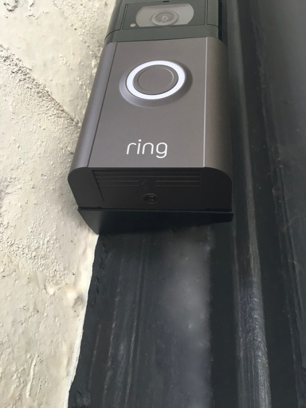 Hands removing a Ring Video Doorbell 2 faceplate with a screwdriver for replacement